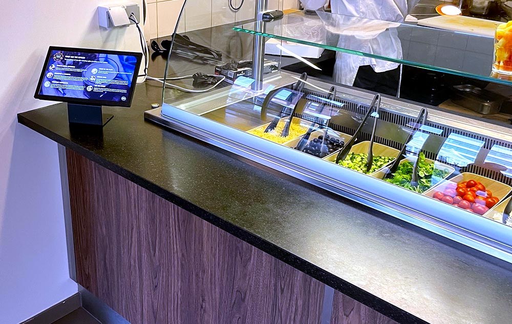 QSR en digital signage toog met eten en saladebar, het scherm is interactief om keuzes te maken.